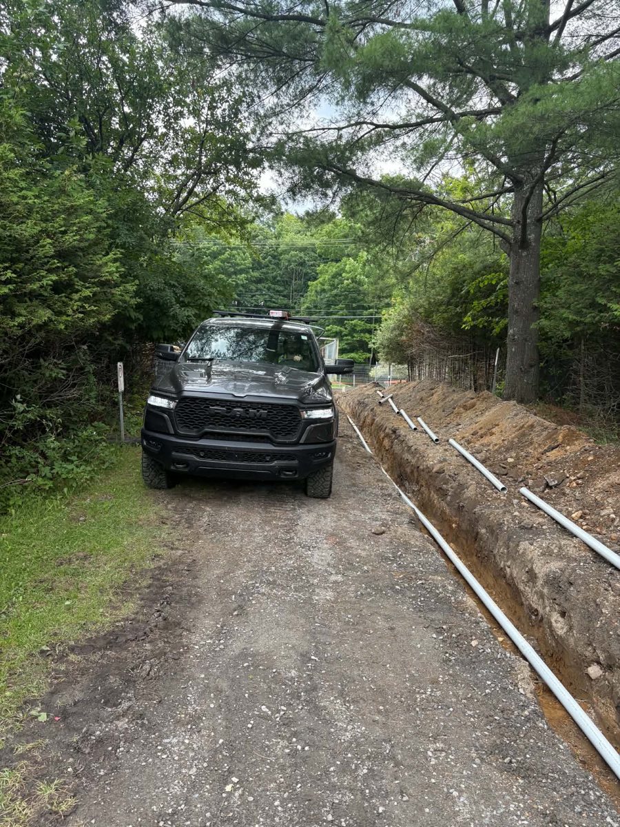 Excavated trench and conduits during preparation of a vehicle access control site