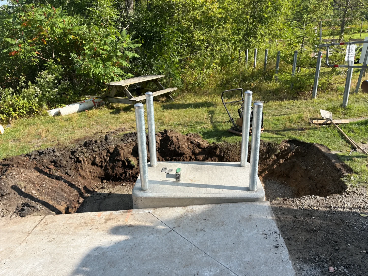 Prefabricated concrete island with protective bollards before access equipment installation